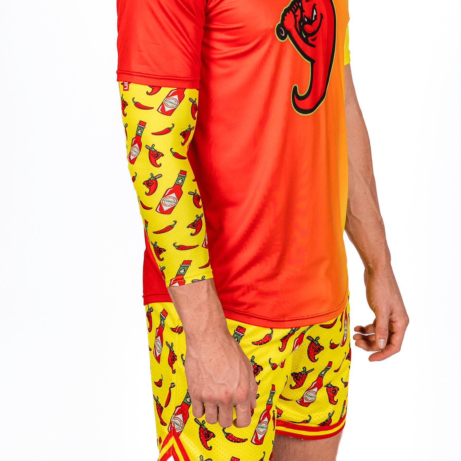 Person wearing a red and yellow outfit with hot pepper and hot sauce baseball arm sleeve