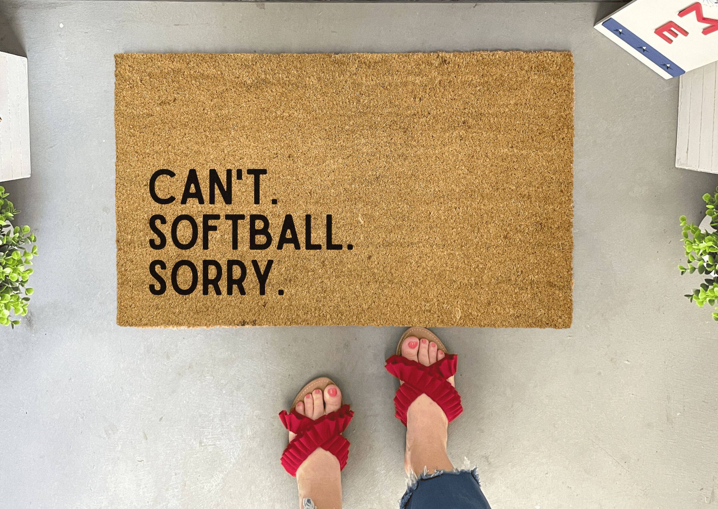 Collection of Doormat with 'CAN'T. SOFTBALL. SORRY.' text on a gray floor. in a gallery layout