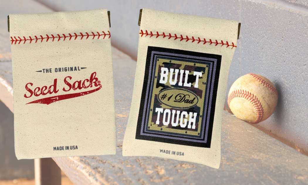 Two seed sacks with vintage design and a baseball on a wooden surface.