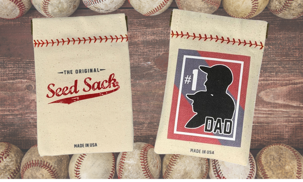 Two seed sacks with baseball-themed designs on a wooden surface with baseballs around.