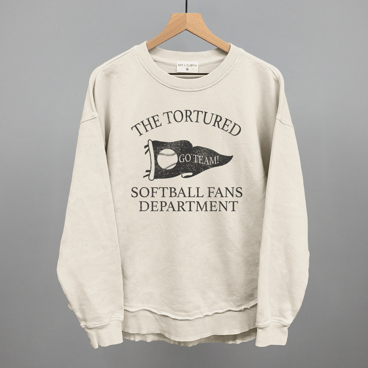 Beige sweatshirt with text that says the tortured Softball fans department