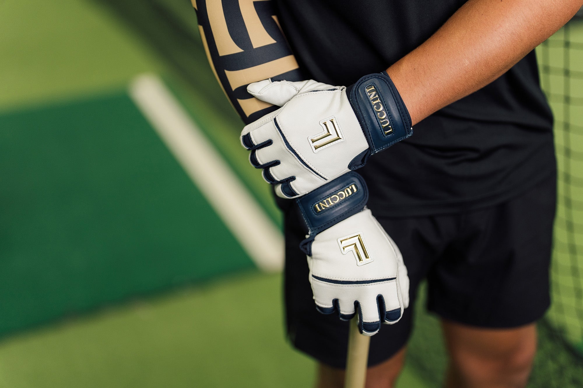 Collection of Person holding a baseball ball wearing luccini blue and white batting gloves in a gallery layout