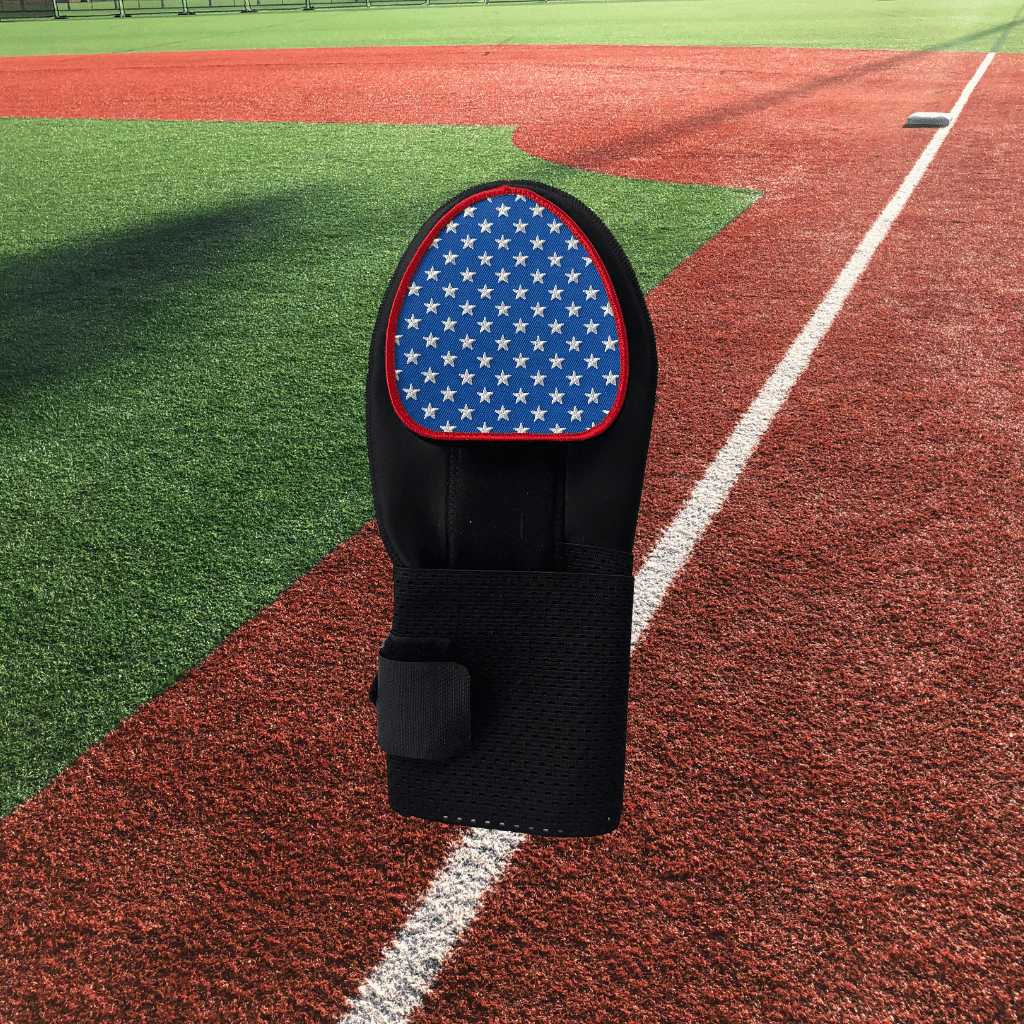Collection of An embroidered patch with a stars and stripes pattern placed on a sliding mitt, displayed on a baseball field. in a gallery layout