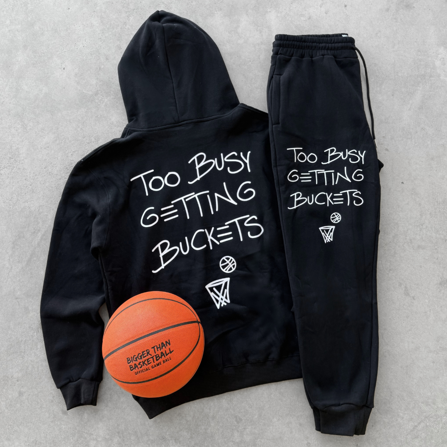 Black hoodie and jogger set with basketball-themed text on a gray background