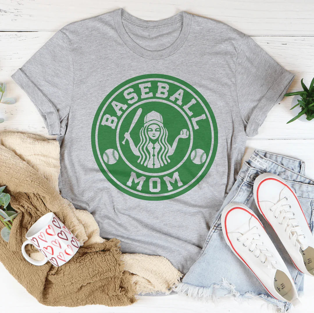 Gray t-shirt with green 'Baseball Mom' graphic on a white surface with accessories.