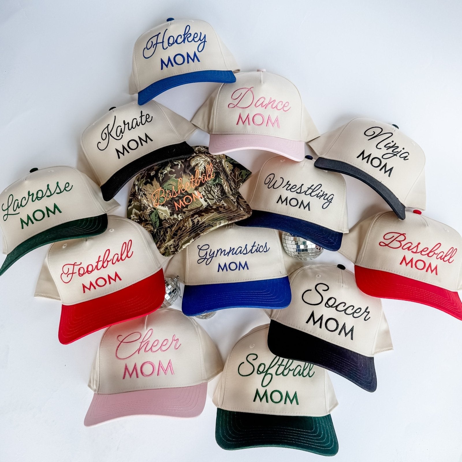 Collection of Collection of 'Mom' themed baseball caps with various sports text on a white background in a gallery layout