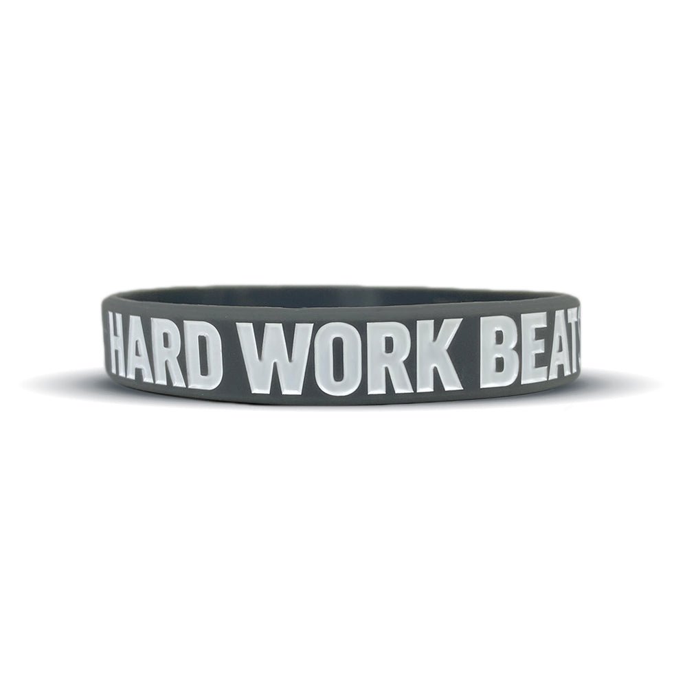 Black wristband with 'HARD WORK BEATS TALENT' text on a white background