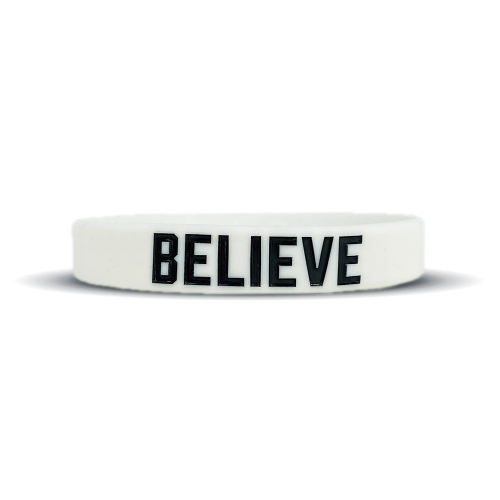 White wristband with 'BELIEVE' printed on it against a white background
